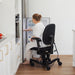 Person reaching into a fridge while sitting in a VELA 700E Activity Chair